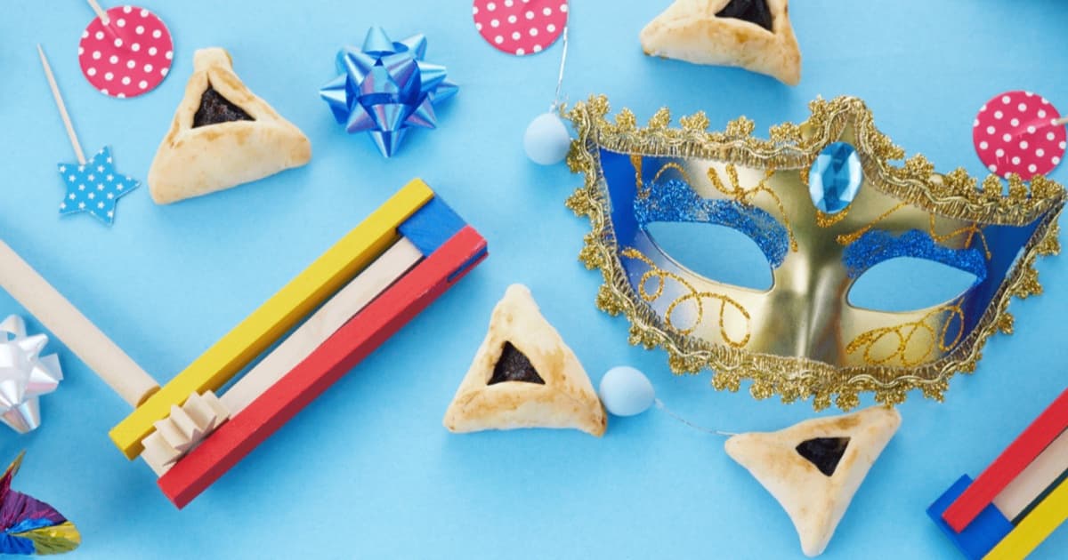 Festa di Purim con biscotti hamantaschen, maschera colorata e raganella di legno